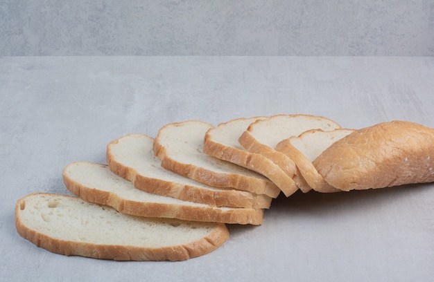 Slices of fresh white bread on marble background. 