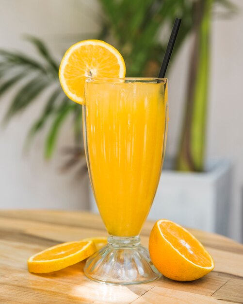 Slices of fruits near glass of drink on table