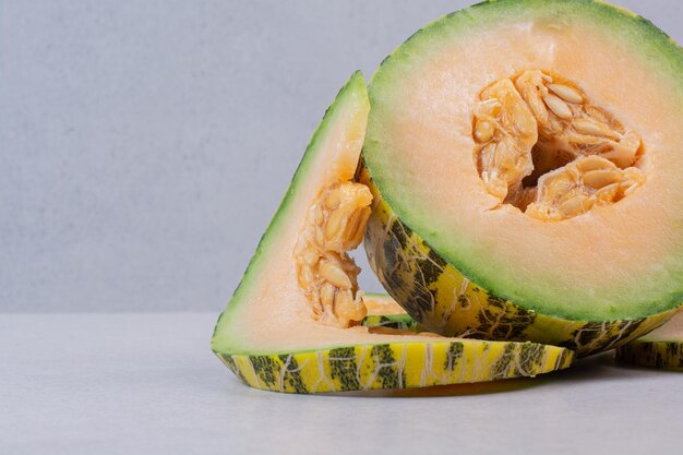 Slices of green melon on white table.