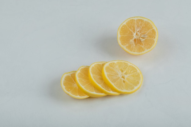 Slices of juicy lemon on a white surface.