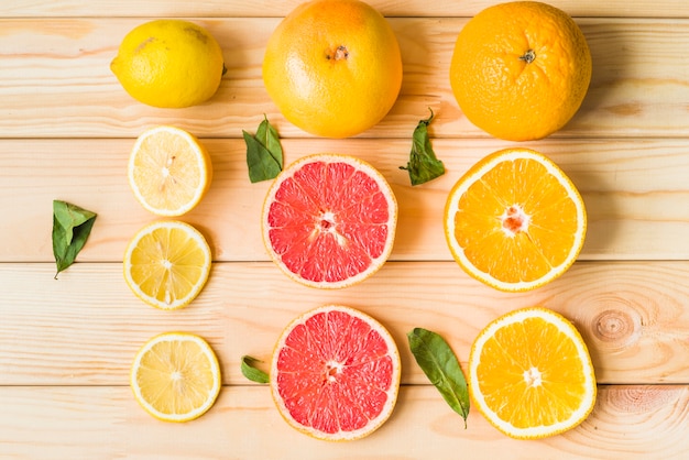 Slices of lemon; grapefruit and orange on wooden background