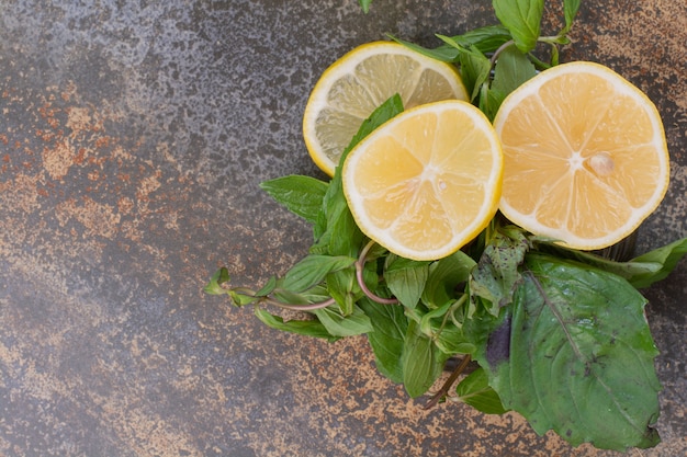 Slices of lemon with mint on marble surface