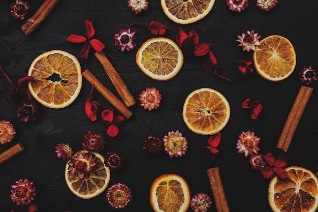 Free photo slices of oranges, cinnamon and flowers