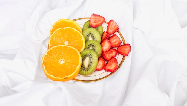 Slices of oranges, kiwi and strawberries on plate