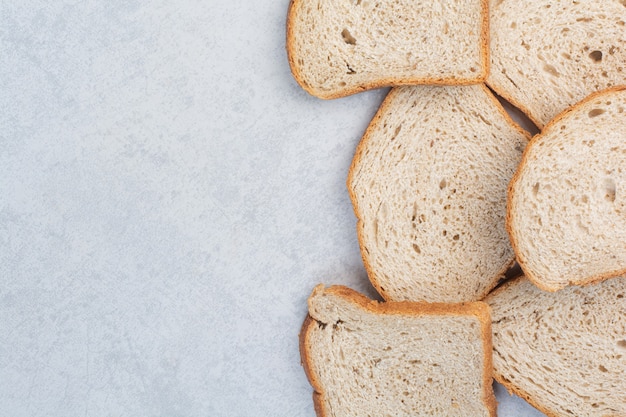 Slices of rye bread on stone surface