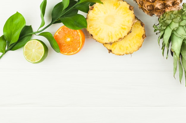 Slices of tropical fruits and green leaves