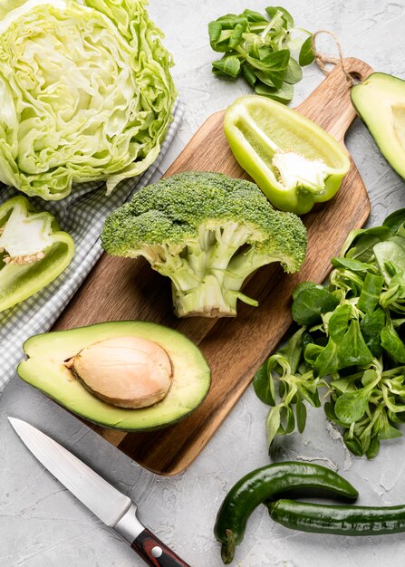 Slices various green veggies with avocado