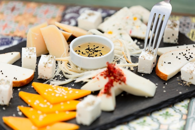 slicing various cheeses with honey