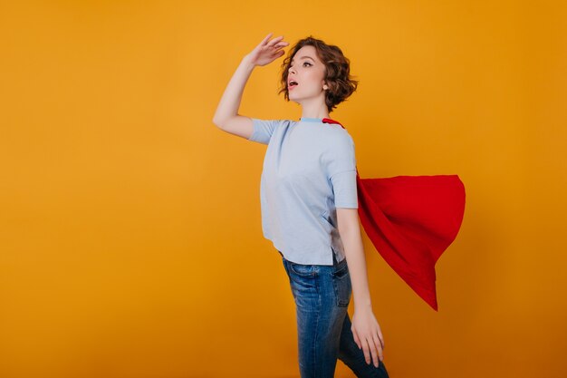 Slim girl in jeans and red mantle having fun 