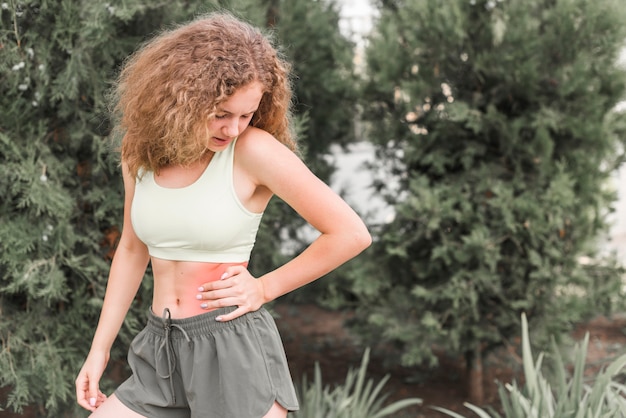 Slim young woman looking at waist injury