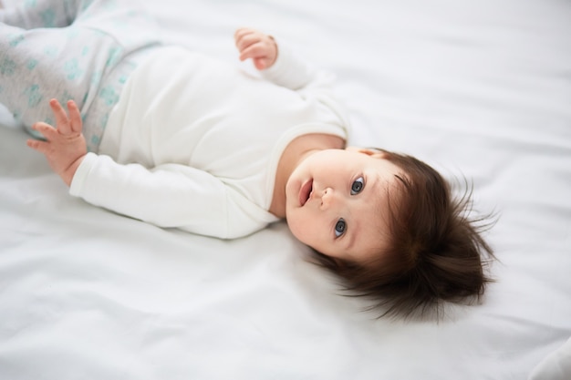 Free Photo the small baby lies on the bed