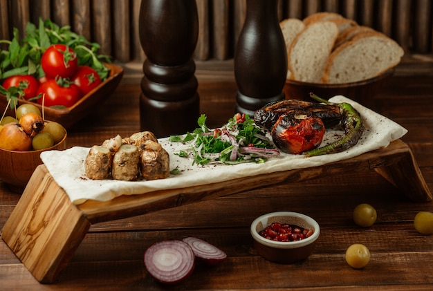 Small baked meat pieces with green salad on a piece of lavash, yukha