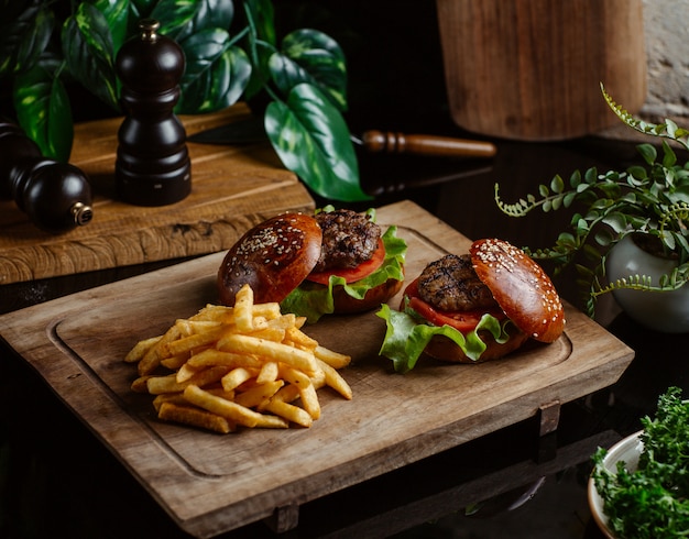 Free photo small beef burgers without cheese on wooden board.