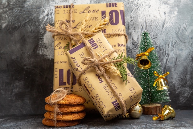 Free photo small and big packed gifts standing on wall and cookies