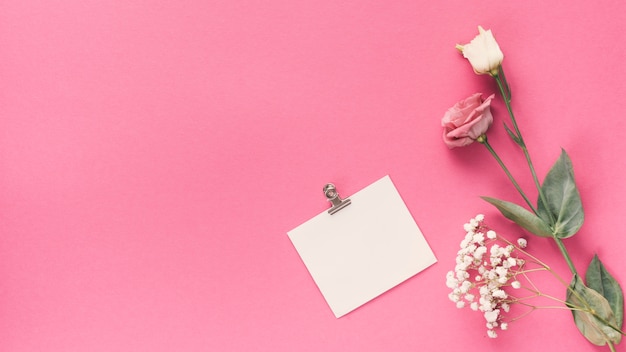 Small blank paper with different flowers on table