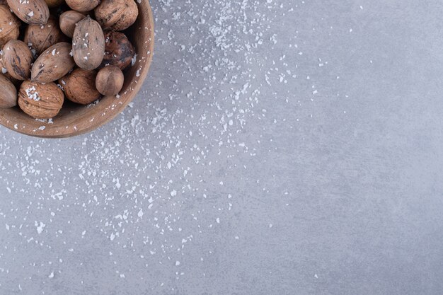 Small bowl of assorted nuts on marble surface