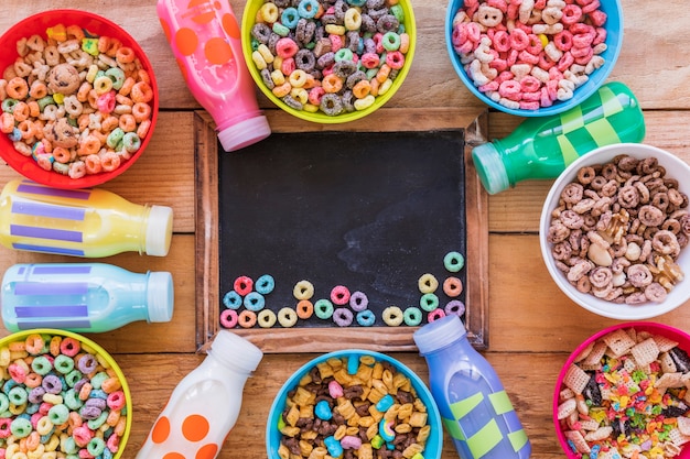 Small bright cereals on chalkboard on wooden table 