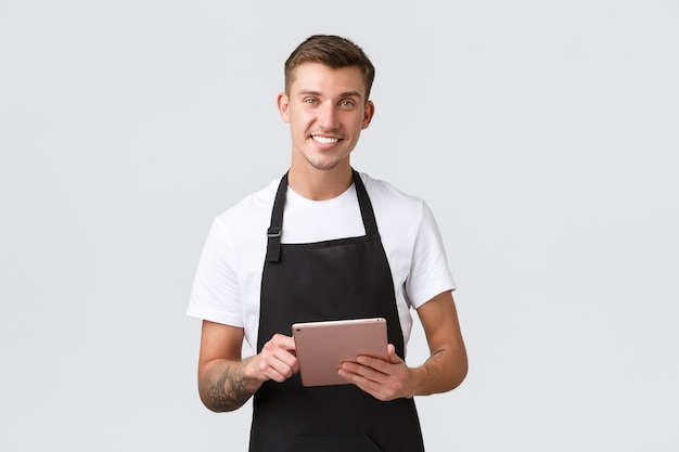 Small business coffee shop and cafe employees concept handsome charismatic smiling barista waiter in...