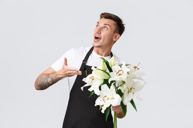 Free photo small business retail and employees concept charismatic handsome florist salesman in flower shop sel...