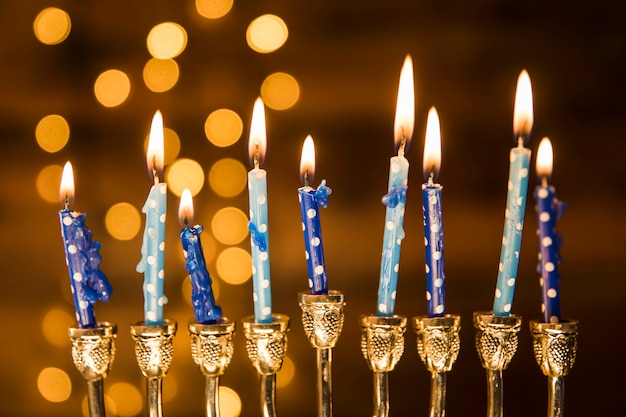 Free photo small candles of menorah near abstract lights