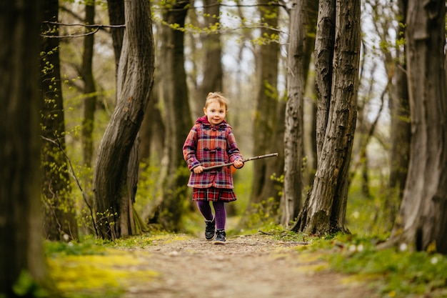 The small child keeping  a trunk and walking along park 