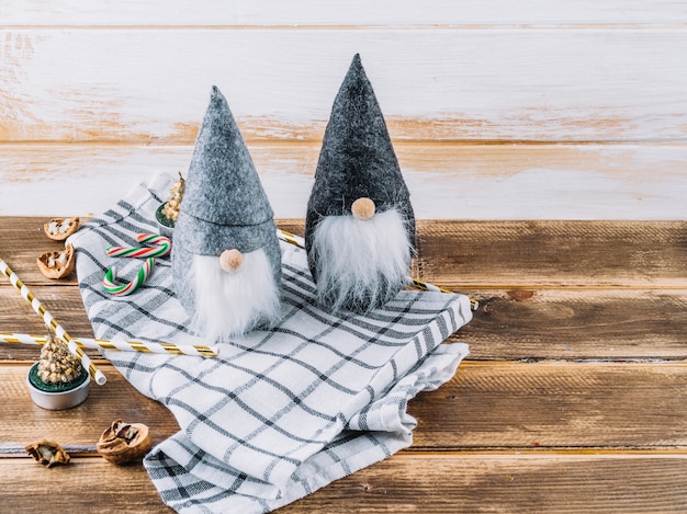 Small Christmas elves with candy canes on table 