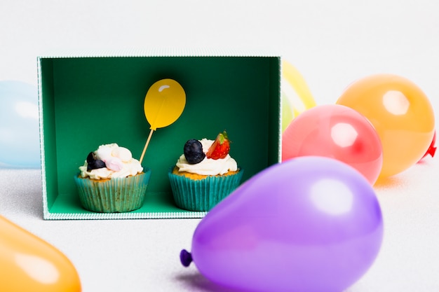 Small cupcakes in box with air balloons