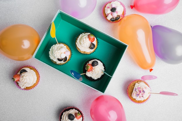 Small cupcakes with air balloons on table