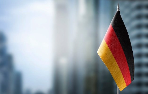 Free photo a small flag of germany on blurred city