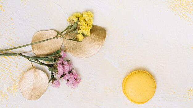 Small flowers branches with cookie on white table