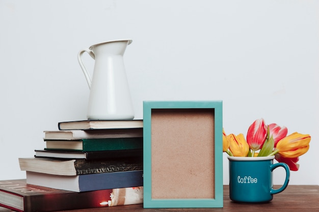 Small frame near flowers and books