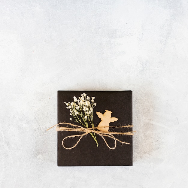 Free photo small gift box with green branch on table