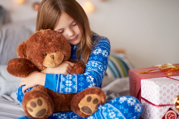 Small girl bonding teddy bear in Christmas