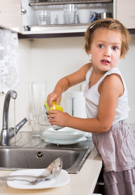 Small girl chores washing dishes