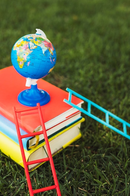 Free Photo small globe arranged on top of books stack