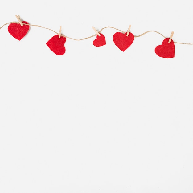 Small hearts pinned to rope on table 