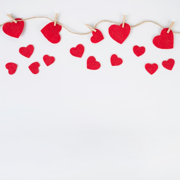 Small hearts pinned to rope on white table