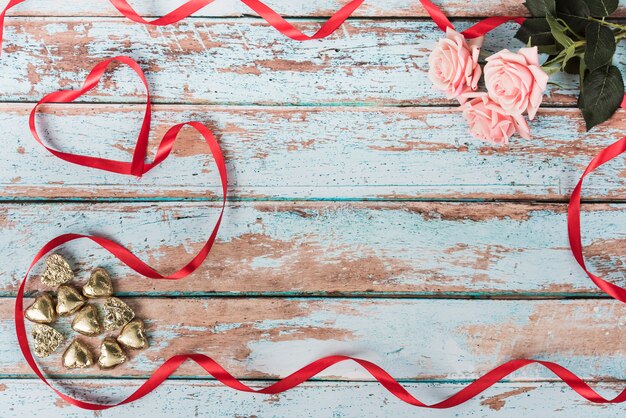 Small hearts with pink roses on table 