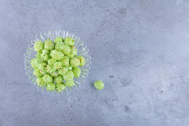 Small, ornate glass saucer with a pile of flavored popcorn on marble surface