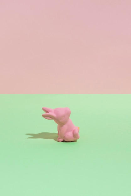 Free photo small pink toy rabbit on green table