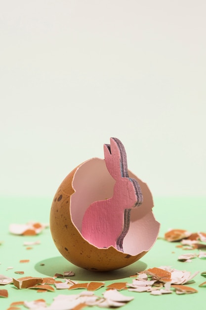 Free photo small pink wooden rabbit in broken egg