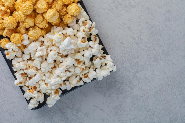 Free photo small platter of popcorn candy and salty popcorn on marble surface