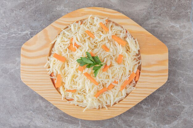 Small portion spaghetti with greens and carrots , on the marble.