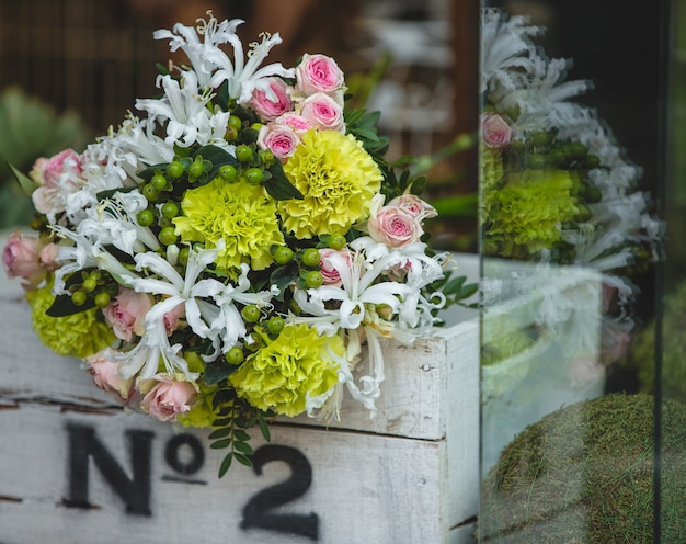 Free photo a small and pretty bouquet of colorful flowers inside a white wooden box