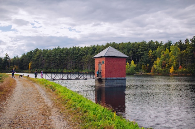 Free photo small red hut built on a river and connected to a bridge with amazing natural scenery