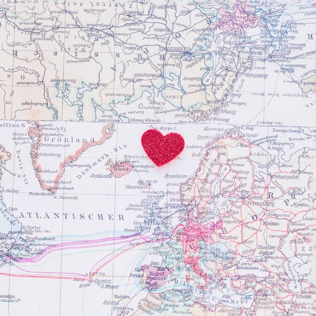 Small red paper heart on world map