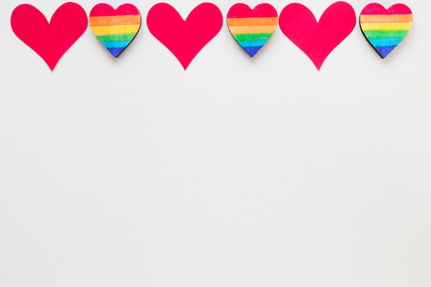 Small red paper and rainbow hearts on table