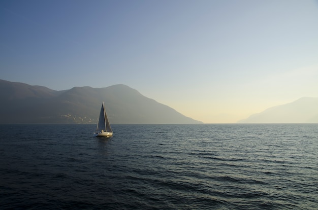 Free Photo small sailing boat in the lake with the sunset