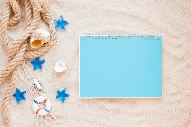 Free photo small sea shells with nautical rope and notebook