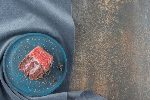 Small slice of cake on a blue platter on a piece of fabric 